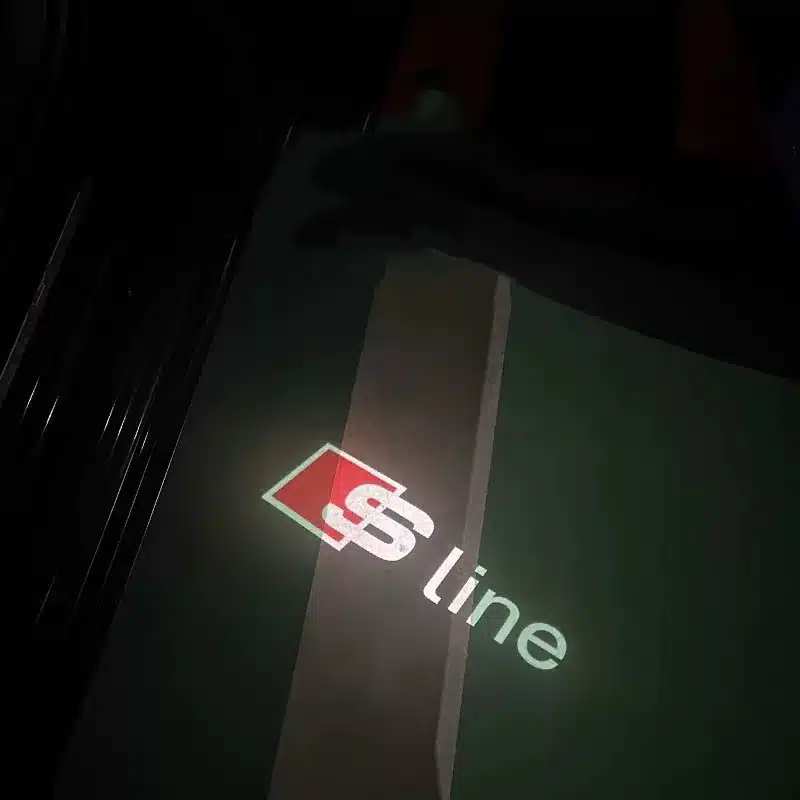 audi s line puddle lights Audi S Line door puddle lights projecting the red and white S Line logo onto the ground.