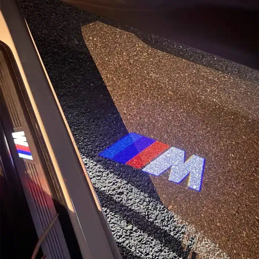 BMW M Puddle Lights Luxury BMW M puddle lights displaying logo on driveway as car door opens, popular in UK automotive styling