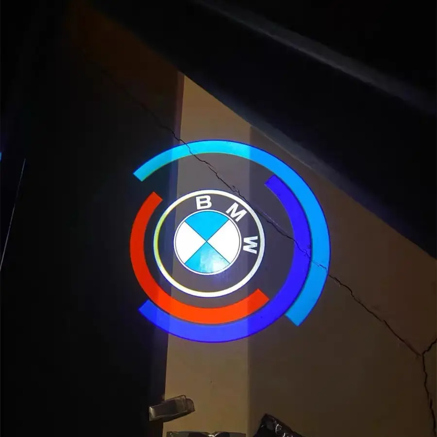 BMW 50th Anniversary Door Lights BMW logo projected on a wall, surrounded by blue and red semi-circles. The background is dimly lit, creating a modern, dynamic feel.