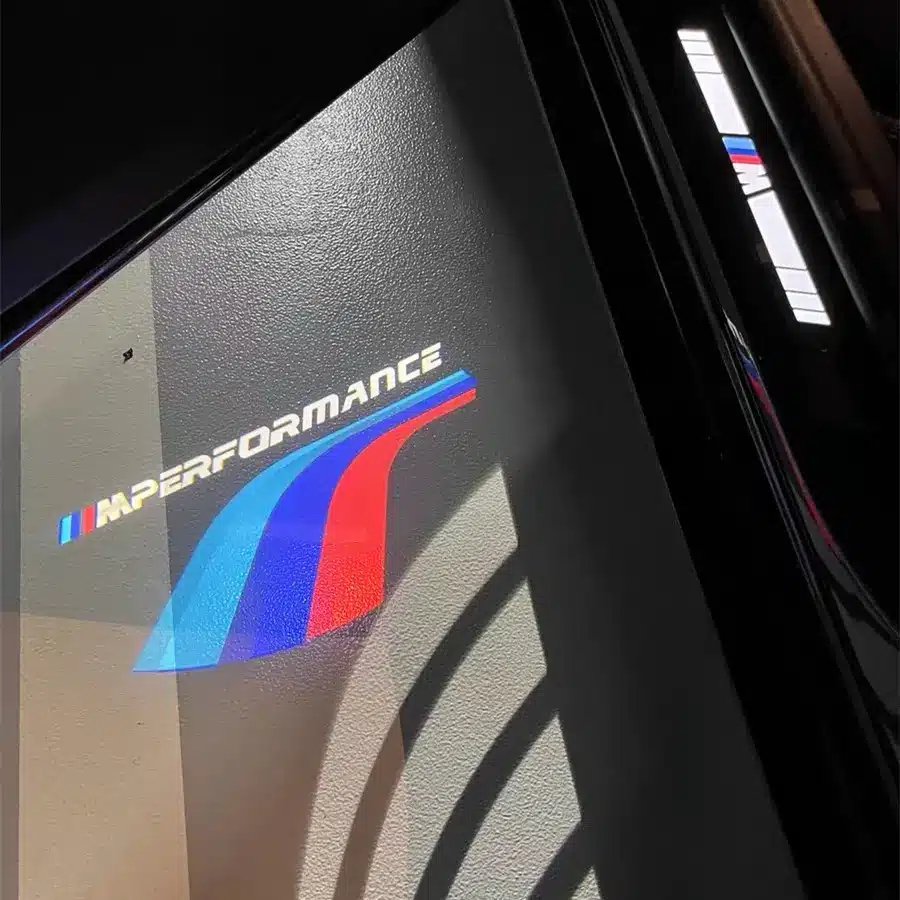 M Sport Puddle Lights BMW logo displayed on the door of a car, showcasing the brand's iconic design and luxury automotive identity.