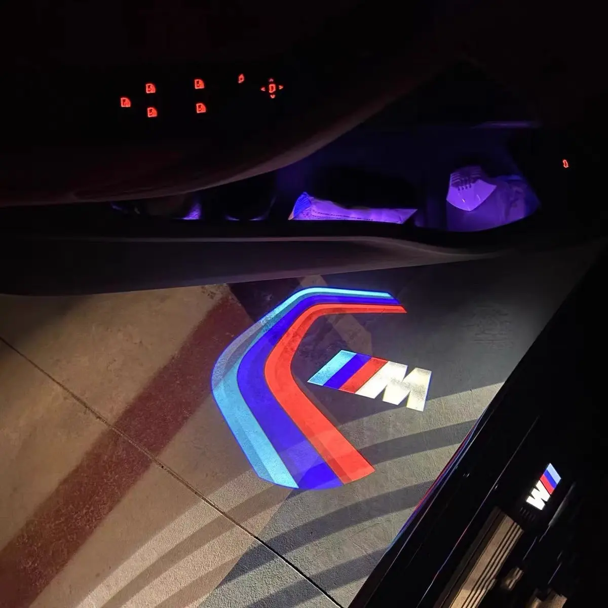 BMW M Sport Door Lights Sleek BMW 3M Sport door lights displaying logo on wet street surface, ideal for UK night driving conditions