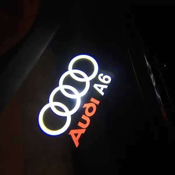 Audi A6 Puddle Lights Close-up of Audi A6 puddle lights casting bright emblem on pavement in low-light UK setting